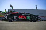 Black and red Lamborghini race car number 45 with DEX Imaging logo parked on racetrack under clear sky.