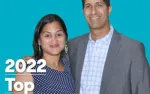 Smiling couple posing against turquoise background with 2022 Top text overlay