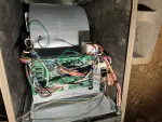 AC Repair and Maintenance in Alpharetta 30005 by The Air Company of GA. Open electronic control panel of HVAC system showing circuit board and colorful wiring inside metal housing.