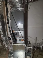 AC Residential Repair in Smyrna by The Air Company of GA.  Residential HVAC system with insulation-covered ductwork and visible warning labels in basement setting.