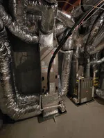 Alpharetta New Unit HVAC Installation and Duct Work by The Air Company of GA.  Industrial HVAC system with insulated ductwork and two furnaces installed in a basement or utility room.