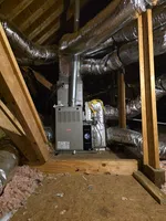 Alpharetta New Unit HVAC Installation and Duct Work by The Air Company of GA. Heating furnace and insulated ductwork installed in a residential attic with wooden framing and insulation.