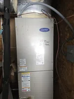 Atlanta Doraville AC Repair by The Air Company of GA.  Carrier HVAC unit installed in an insulation-lined utility space with pipes and wiring visible.