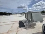 Commercial HVAC Repair in Alpharetta by The Air Company of GA. Commercial rooftop with multiple HVAC units under a partly cloudy sky during daytime.