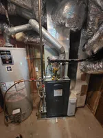 HVAC Real Estate Inspection in Atlanta by The Air Company of GA.  Residential furnace and water heater setup in basement with ductwork and ventilation pipes.