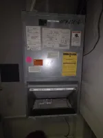Smyrna HVAC Diagnostic Repair and Replacement by The Air Company of GA. Metal HVAC air handler unit with various warning and energy guide labels, filter visible inside the open compartment.