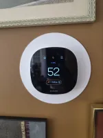 Furnace Repair in Marietta 30062 by The Air Company. Ecobee smart thermostat on a brown wall showing temperature 52 degrees and humidity 30%.