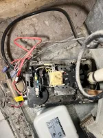 Ac Repair and Maintenance in Smyrna 30080 by The Air Company of GA.   Open furnace or heating unit showing internal wiring, fan, transformer, and connected pipes in dusty basement area.