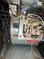 Furnace Heating Repair in Alpharetta 30009 by The Air Company of GA.  Close-up of an HVAC system's control board with multicolored wires and a motor inside a metal casing.