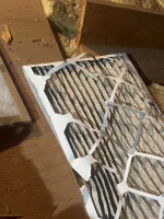 Furnace Heating Repair in Atlanta Decatur 30030 by The Air Company of GA.  Used pleated air filter with dust and debris trapped in the fibers on wooden surface in attic space
