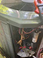 AC Repair and Preventative Maintenance in Alpharetta by The Air Company of GA. Open air conditioning unit with exposed wiring and a digital multimeter attached for electrical testing outdoors.