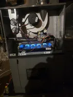 Heating Control Board Repair Atlanta 30324 by The Air Company of GA.  Open furnace showing active blue flames, wiring, and internal components in a basement setting.