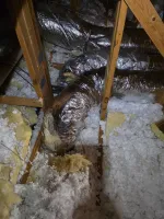 Commercial HVAC Duct Repair in Marietta 30066 by The Air Company of GA.  Attic duct work with exposed wooden beams, reflective HVAC ductwork, and loose white and yellow insulation.