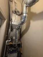 Heating Furnace Repair Marietta 30066 by The Air Company of GA.  Residential HVAC system with exposed ductwork, insulation, and a drill on top in a narrow utility space.