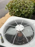 AC Repair in Roswell 30076 by The Air Company of GA.  Outdoor central air conditioning unit with large fan and protective grill sitting near shrubbery.