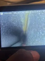 Furnace Heating Repair in Atlanta Decatur 30030 by The Air Company of GA.  Hand holding device displaying an inspection camera view inside a narrow, textured pipe or tunnel interior.