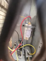 AC-Capacitor-Replacement-Atlanta-30307-HVAC-Repair-The-Air-Company-of-GA.  Electrical capacitor and wiring inside a metal HVAC unit with red, yellow, and black wires connected.