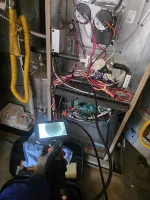 Residential AC Furnace Repair in Marietta 30068 by The Air Company of GA.  Technician using inspection camera to check inside HVAC furnace system with wires and components exposed.