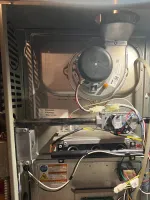 AC Repair and Preventative Maintenance in Alpharetta by The Air Company of GA.  Internal view of a gas furnace showing wiring, control board, blower, and metal components in a residential HVAC system.
