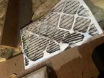 Furnace Heating Repair in Atlanta Decatur 30030 by The Air Company of GA.  Used pleated air filter with dust and debris trapped in the fibers on wooden surface in attic space