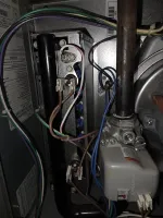 Residential AC Cooling Repair in Atlanta 30318 by The Air Company.  Inside view of furnace electrical wiring and components with various colored wires and metal pipes.