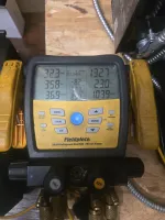 Commercial HVAC Repair in Smyrna 30080 by The Air Company of GA.  Fieldpiece SMAN refrigerant manifold with digital gauge readings for pressure and temperature on wooden surface.