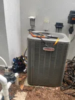Atlanta AC Repair by The Air Company of GA. Outdoor Lennox air conditioning unit installed beside house with coiled hose and maintenance tools.