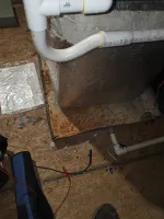 AC Heat Repair in Atlanta 30309 by The Air Company of GA.  Rusty metal drip pan under HVAC unit with white PVC pipes and scattered tools on wooden floor.