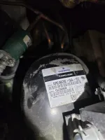 Close-up of Emerson Copeland refrigeration compressor model ARE48C5E-IAA-103 with identifying label and serial number.