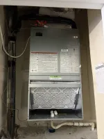 Commercial AC Installation of a Wall Hung Unit by The Air Company of GA.  Indoor view of an HVAC air handler with a visible air filter and connected pipes inside a utility closet.