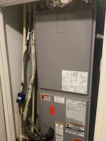 Sandy Springs Residential AC Repair by The Air Company of GA. Indoor HVAC unit with pipes, wiring, warning labels, and a manual in a utility closet.