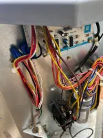 AC Repair and Maintenance in Smyrna 30080 by The Air Company of GA. Close-up of electrical wiring and circuit board inside an HVAC unit with multicolored wires and metal casing.