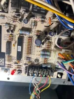 Heating Furnace Repair in Alpharetta 30009 by The Air Company of GA.  Close-up of a circuit board with resistors, capacitors, chips, and colorful wires connected to terminals.