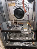 Residential AC Maintenance in Norcross by The Air Company of GA. Open furnace showing gas valve, burner assembly, and wiring inside metal housing for heating system.