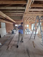Man posing inside an unfinished wooden interior construction site with tools and ladder.  HVAC Repair in Atlanta 30341 by The Air Company of GA.