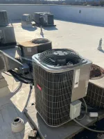 Heating Furnace Repair in Sandy Springs 30350 by The Air Company of GA.  Row of rooftop air conditioning units installed on a flat commercial building roof under sunlight.