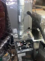 Atlanta AC Repair by The Air Company of GA. Residential HVAC system installation including air ducts, pipes, and furnace components in a basement setting.