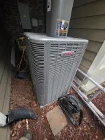 hvac-system-repair-and-capacitor-replacement-atlanta-30307-the-air-company-of-ga Lennox air conditioning unit installed outside house with tools and ladder nearby on pine straw.