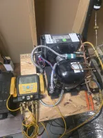 Commercial HVAC Repair in Smyrna 30080 by The Air Company of GA.  HVAC compressor unit on wooden board connected to Fieldpiece gauge manifold with yellow hoses and copper pipes.