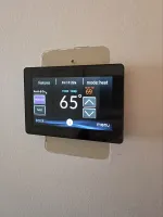 HVAC Thermostat Repair in Atlanta 30327 by The Air Company.  Digital thermostat mounted on wall showing current room temperature 65 degrees and heating set to 69 degrees Fahrenheit.