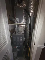 Commercial AC Heating Repair in Atlanta Dunwoody 30338 by The Air Company of GA.  Closet housing an Airease furnace with insulated ductwork and ventilation pipes in a residential setting.