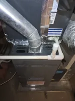 Furnace Heating Repair in Sandy Springs Atlanta 30328 by The Air Company of GA.  Daikin furnace unit with metal ventilation pipe and white PVC drainage pipes in a basement setting.