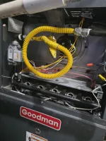 Commercial HVAC Repair in Dunwoody 30338 by The Air Company of GA.  Interior of a Goodman furnace showing yellow gas line, wiring, and burner assembly.