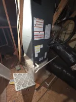 AC Heat Repair in Atlanta 30309 by The Air Company of GA.  Furnace unit installed in attic with air filter removed and exposed ductwork on plywood floor.