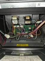 Heating Control Board Repair Atlanta 30324 by The Air Company of GA.  Close-up of electrical control board with colorful wires inside an appliance metal housing with warning labels.