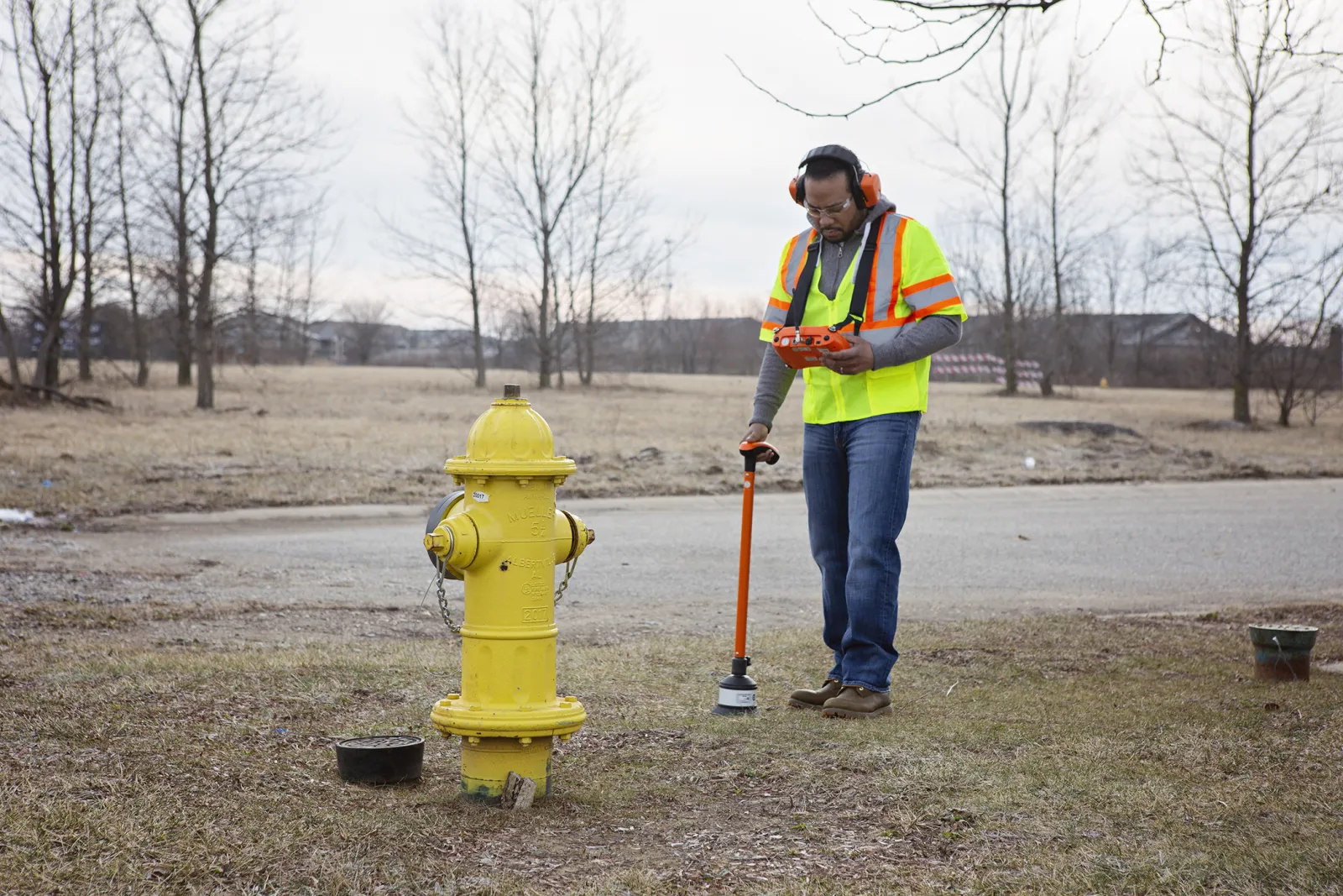 Man performing underground utility location services for a leak survey or water audit