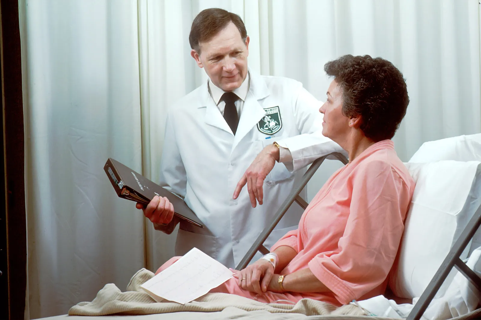 A doctor talking to a patient in hospital bed