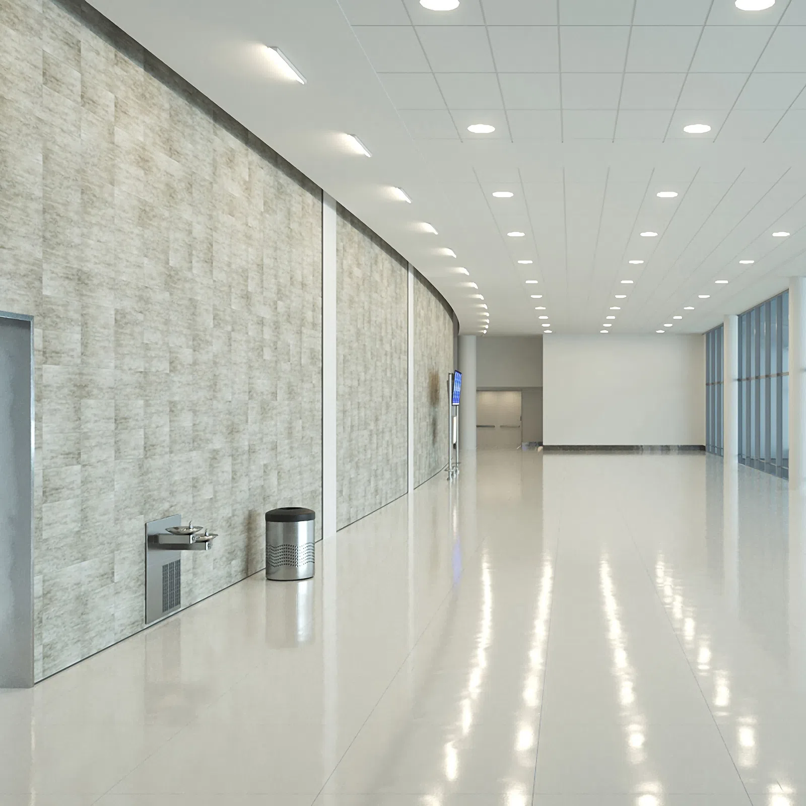Bright modern hallway with polished floor, large windows, textured wall, drinking fountain, and trashcan.