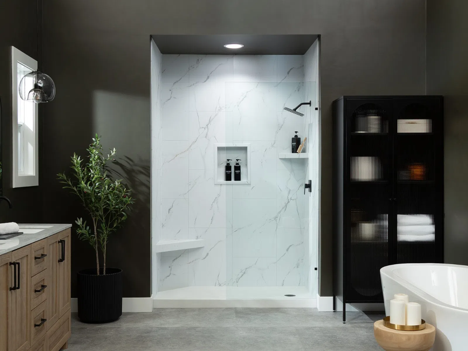 Modern bathroom with freestanding tub, wooden vanity, glass shower, and dark green walls.