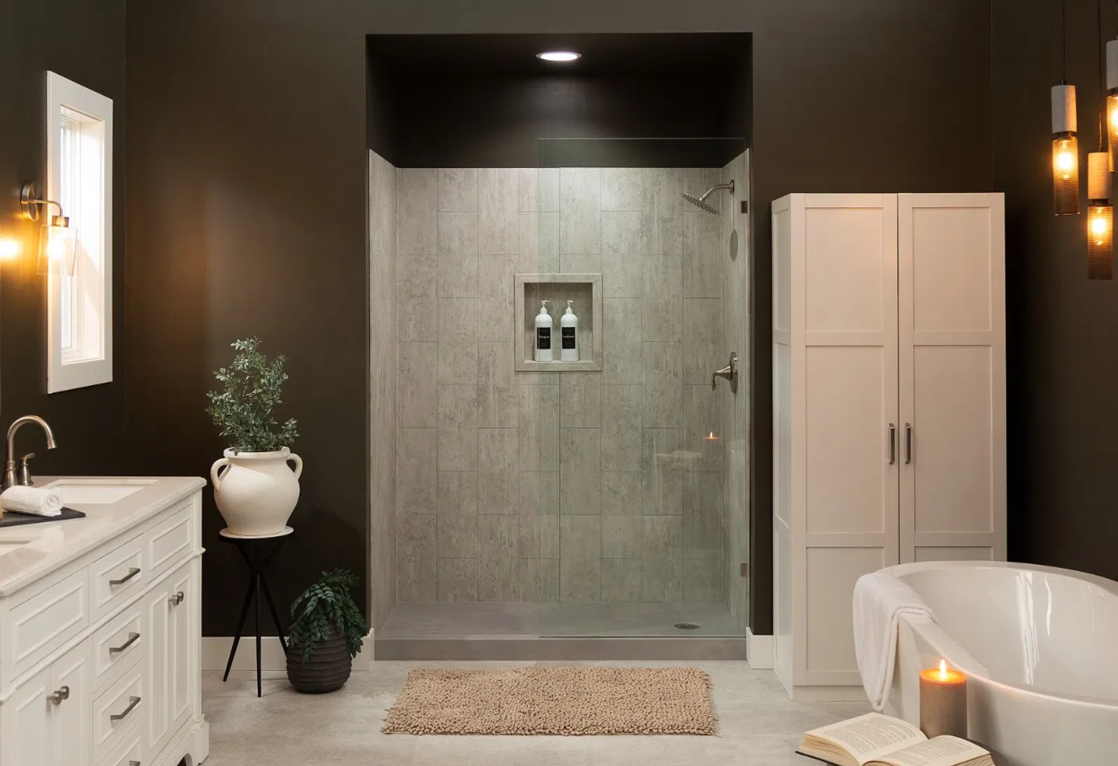 Modern bathroom with white vanity, freestanding tub, glass shower, dark walls, and soft lighting